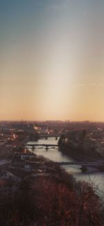 High angle view of illuminated city against sky at sunset