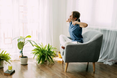 Young woman sitting on sofa at home