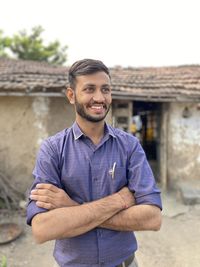 Portrait of young man standing against wall