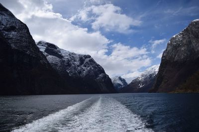 Scenic view of lake by mountains against sky