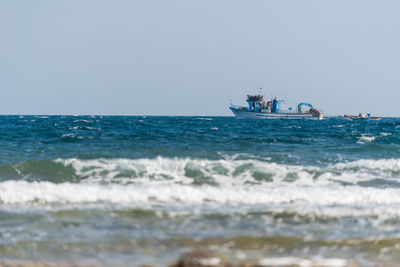 People in sea against clear sky