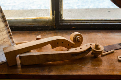 Close-up of old metal on table by window