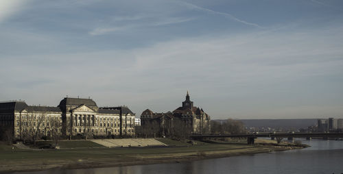 River by buildings against sky in city