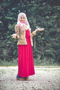 Portrait of woman standing against trees