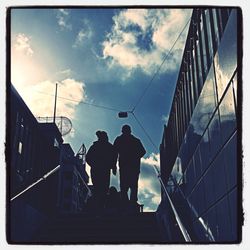 Low angle view of man standing on bridge against sky