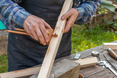 Midsection of man working on wood