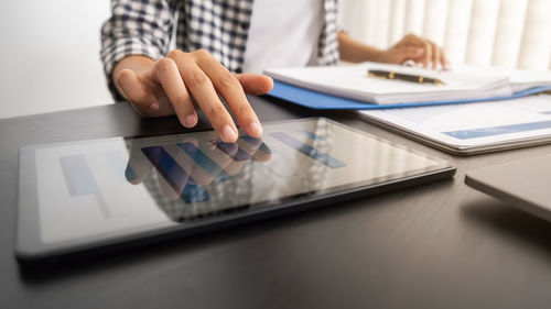 Midsection of man using laptop on table