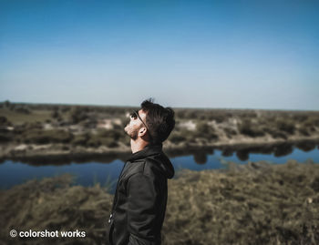 Side view of young man standing on land