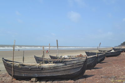 Boats moored at beach during sunny day