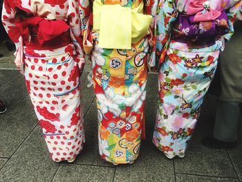 Low section of woman wearing multi colored shoes