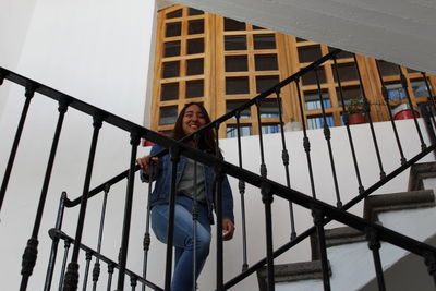 Low angle view of young woman standing on staircase