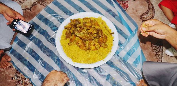 High angle view of woman holding food on table