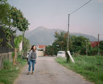 Full length of man walking on road against sky