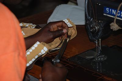 Midsection of woman stitching in workshop