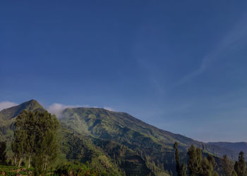 Scenic view of mountains against blue sky