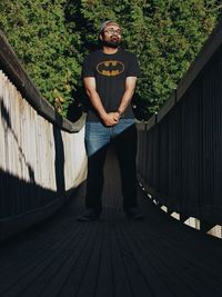 Portrait of young man standing on footbridge