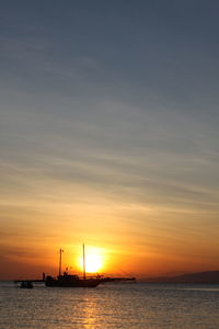 Silhouette sailboats in sea against sky during sunset