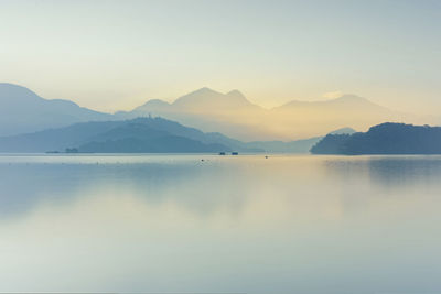 Scenic view of lake and mountains against sky