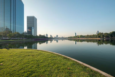 Scenic view of lake by buildings against clear sky