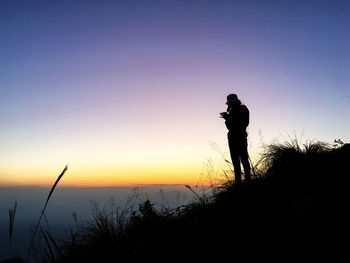 Silhouette man standing against sky during sunset