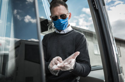 Man wearing sunglasses and gloves in bus