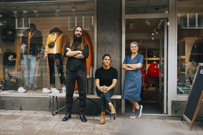 Portrait of male and female colleagues outside clothes store