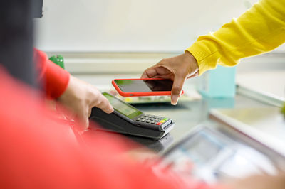 Crop woman using smartphone in office