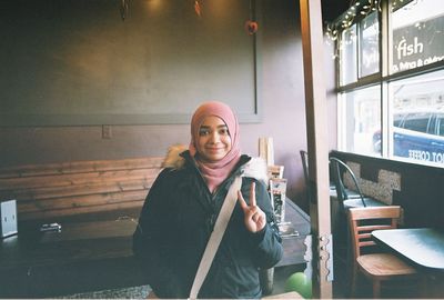 Portrait of smiling young woman sitting at restaurant