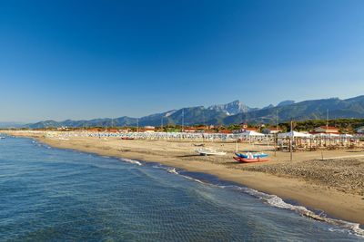 Scenic view of beach against clear blue sky