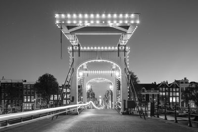 Illuminated road against sky in city at night