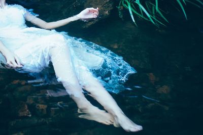 Low section of woman relaxing in water