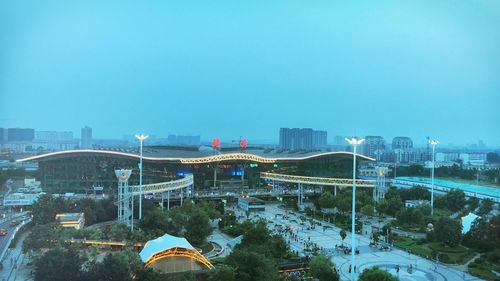 Bridge over river amidst buildings against clear blue sky