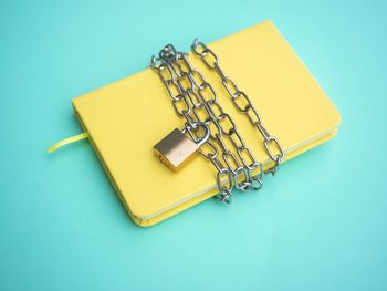 High angle view of yellow container on table against blue background