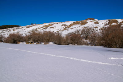 Scenic view of snowcapped mountains against clear blue sky