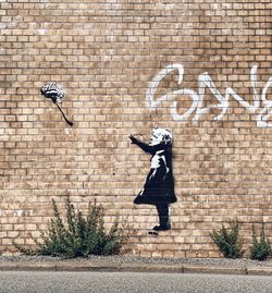 Side view of graffiti on brick wall