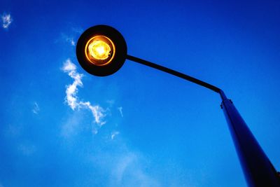 Low angle view of illuminated street light against blue sky