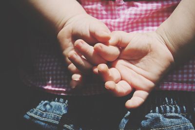 Midsection of child holding hands