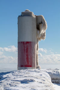 Close-up of snow on land against sky