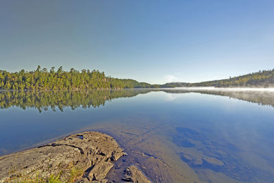 Scenic view of lake against clear blue sky