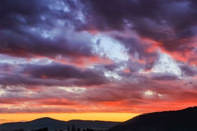 Scenic view of dramatic sky over silhouette landscape