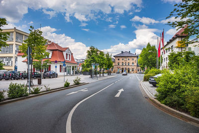 Street amidst houses and buildings against sky