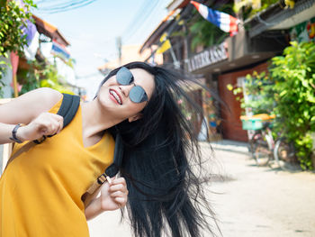 Young woman tossing hair while standing outdoors