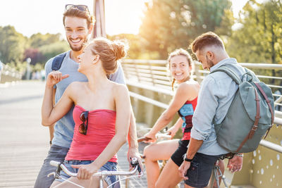 Friends with bicycles on bridge