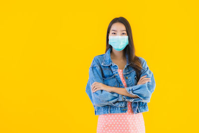 Portrait of a beautiful young woman against yellow background