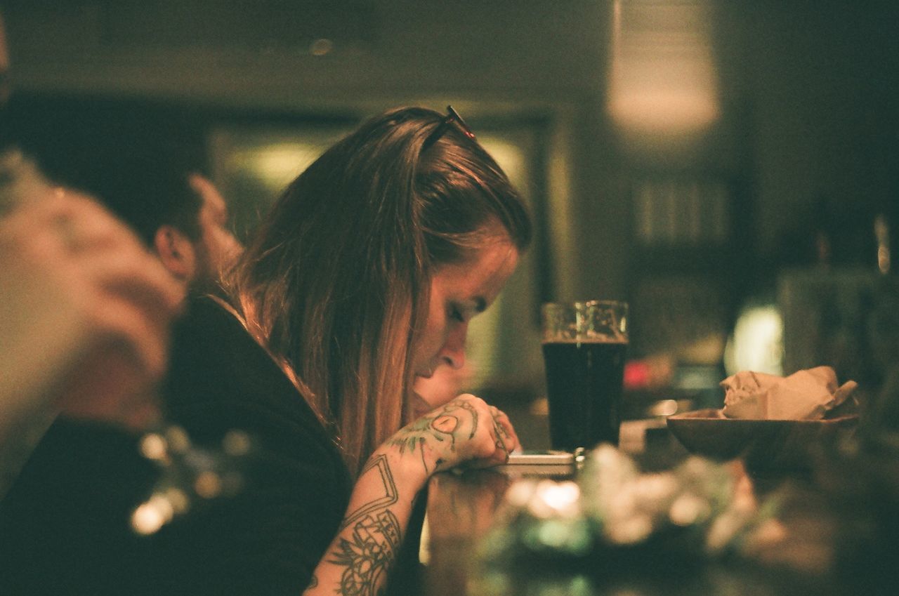 food and drink, drink, refreshment, real people, indoors, lifestyles, glass, selective focus, headshot, restaurant, one person, portrait, leisure activity, table, drinking glass, alcohol, drinking, sitting, business, hairstyle