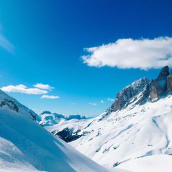 Scenic view of snowcapped mountains against blue sky