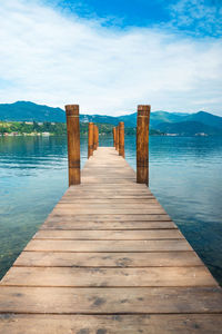 Wooden pier over lake against sky