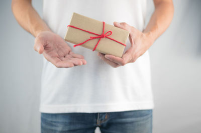 Midsection of woman holding paper with box