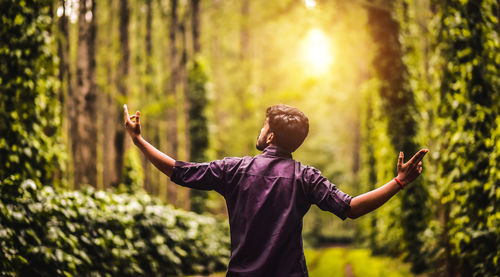 Full length of man standing by tree in forest