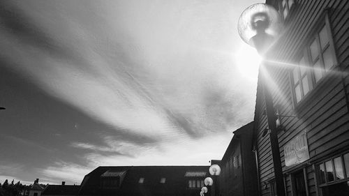 Low angle view of sunlight streaming through buildings